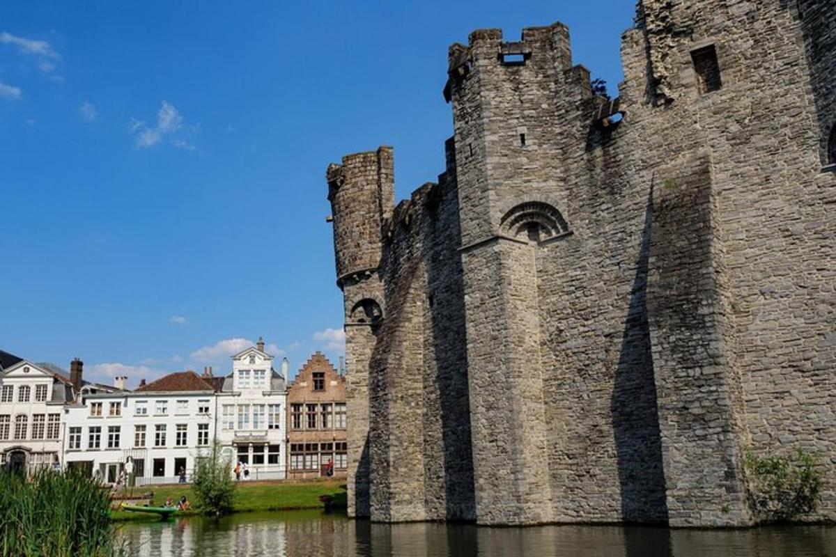 an old castle sitting in the water next to buildings