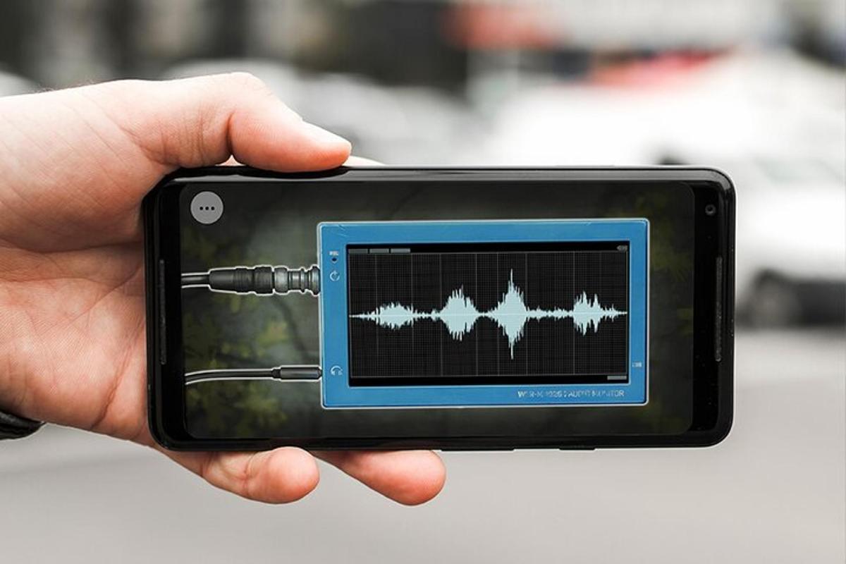 Una mano sosteniendo un teléfono inteligente con un sonido.
