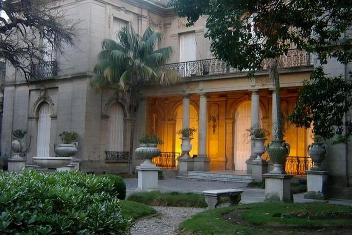 Un edificio con un porche y un banco delante.