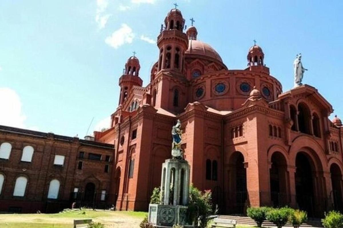 Un gran edificio de ladrillo con una estatua delante.
