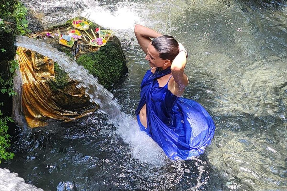 滝の近くの水の中に立っている女性