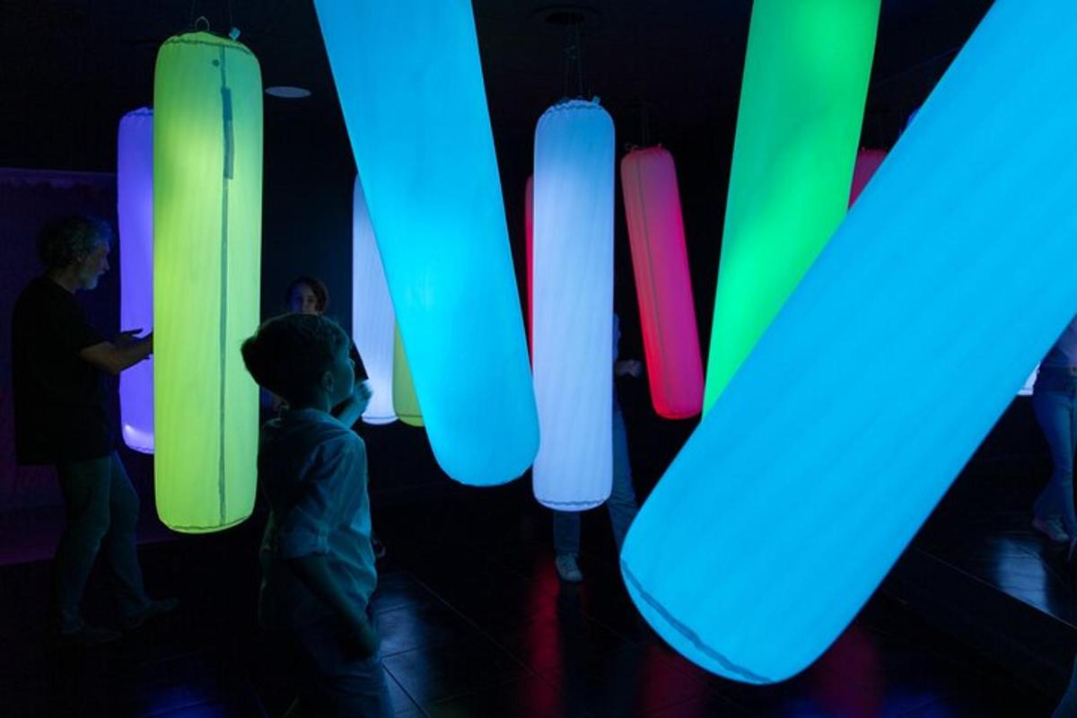 un gruppo di persone in piedi in una stanza con luci colorate