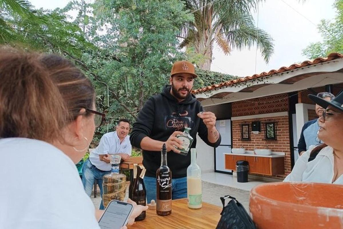 um homem em pé à mesa com uma garrafa de vinho