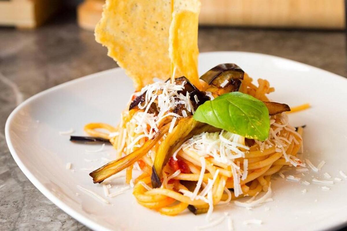 en hvit tallerken med pasta med et stykke brød