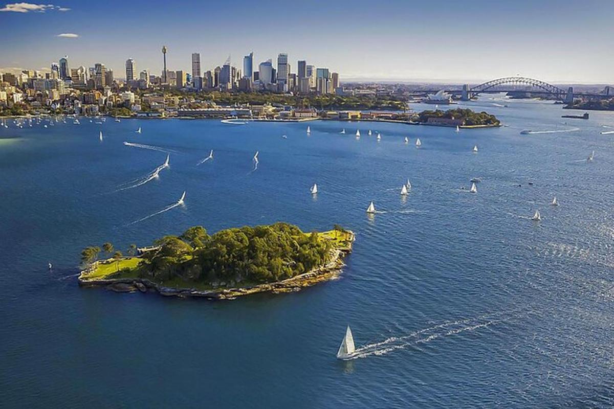 an island with sail boats in the water with a city