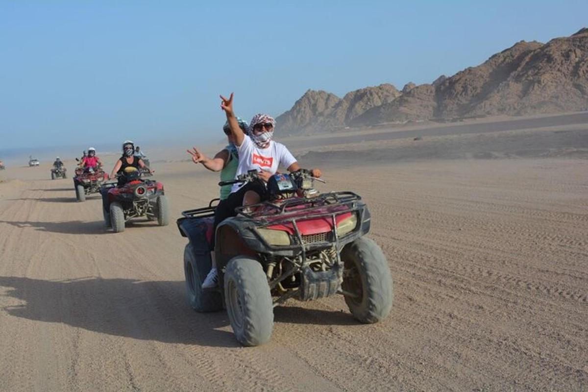 un gruppo di persone in sella a quad nel deserto