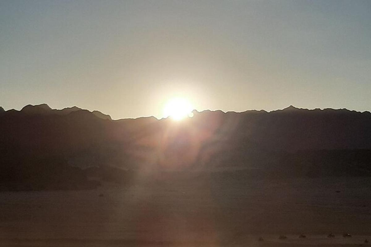 un sole sta tramontando su una catena montuosa