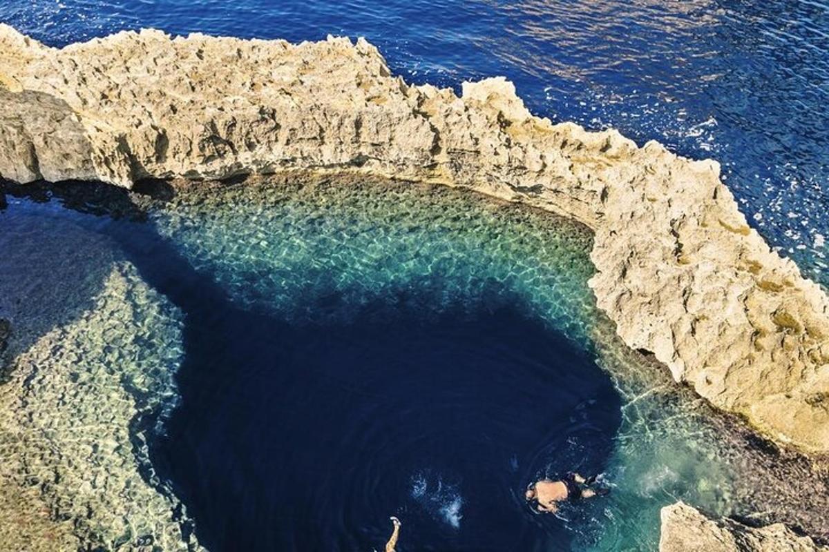 Una vista aérea de un charco de agua junto a unas rocas.