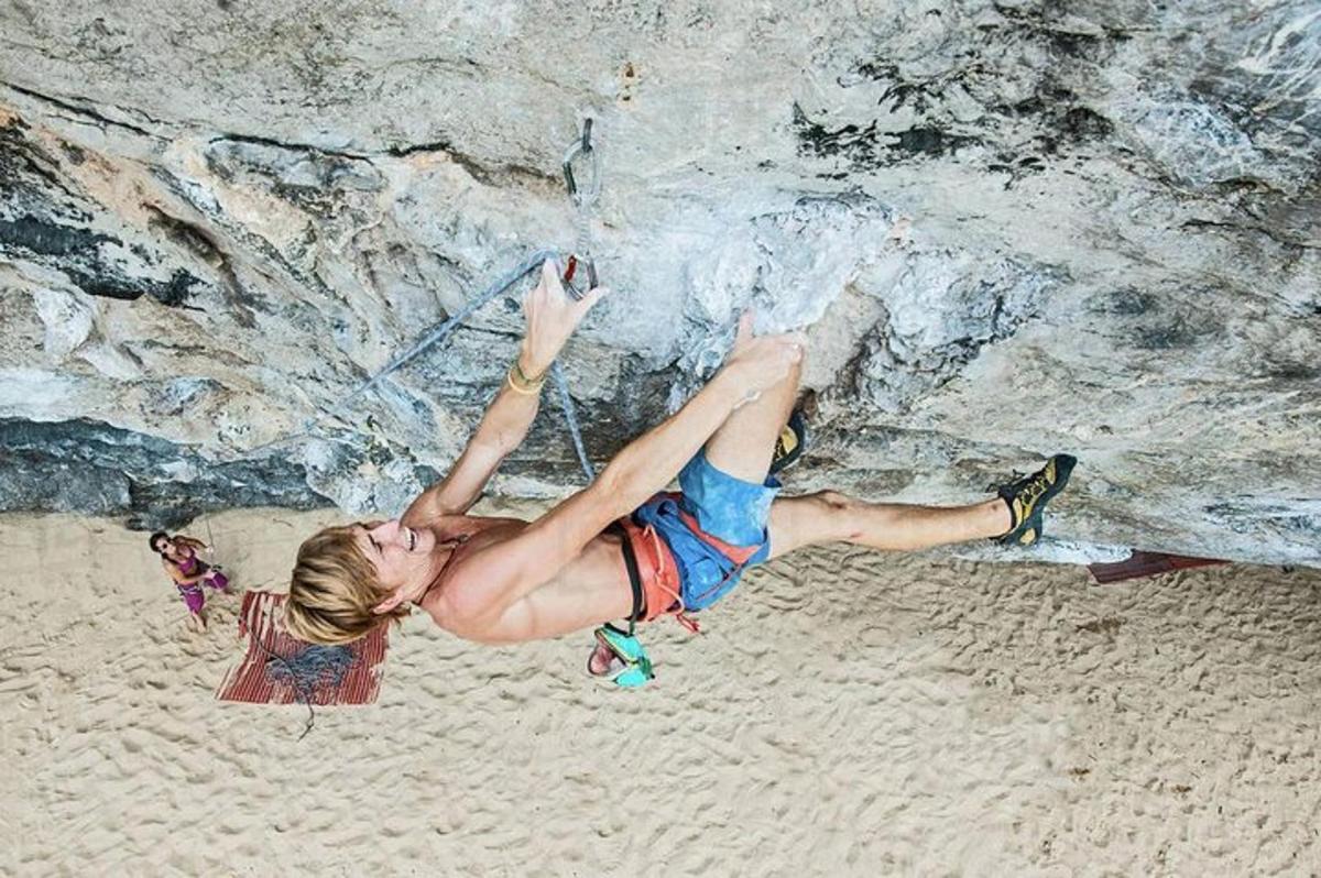 uma mulher está pendurada em uma parede de pedra