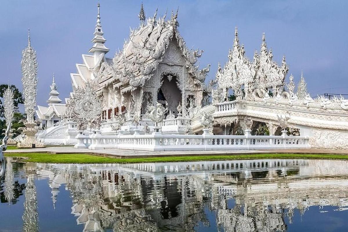 a white temple with its reflection in the water