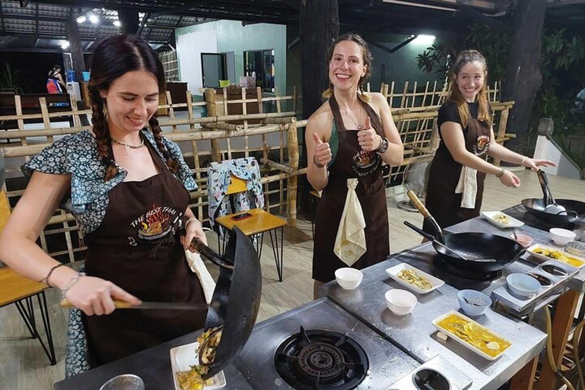 Tres mujeres están preparando comida en una parrilla
