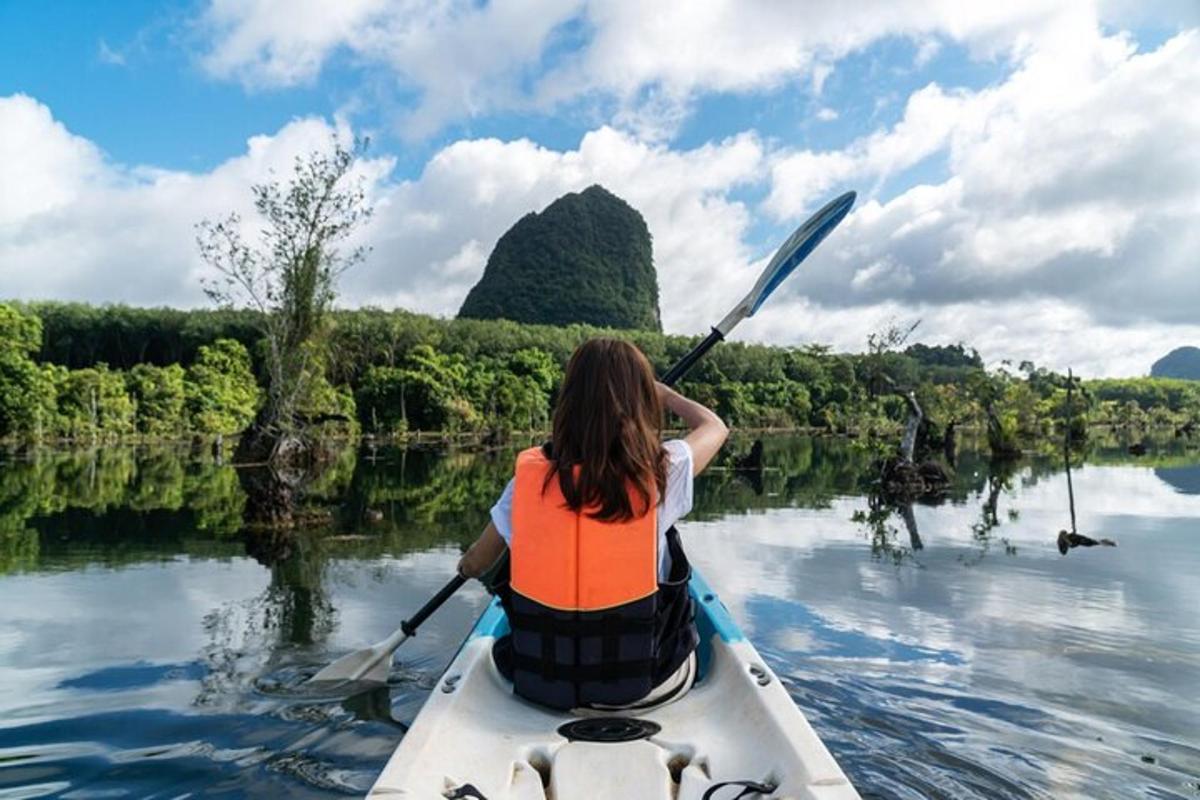 uma mulher está remando uma canoa em um rio