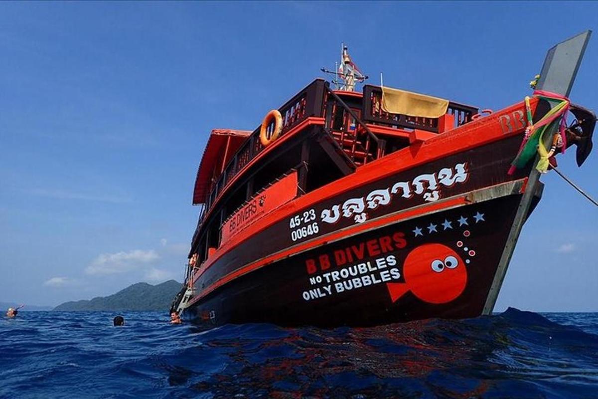 a red boat is sitting in the water