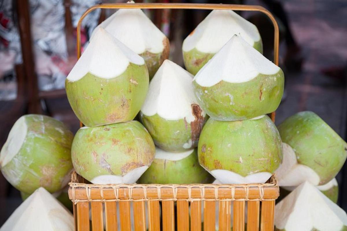 a pile of green coconuts in a basket