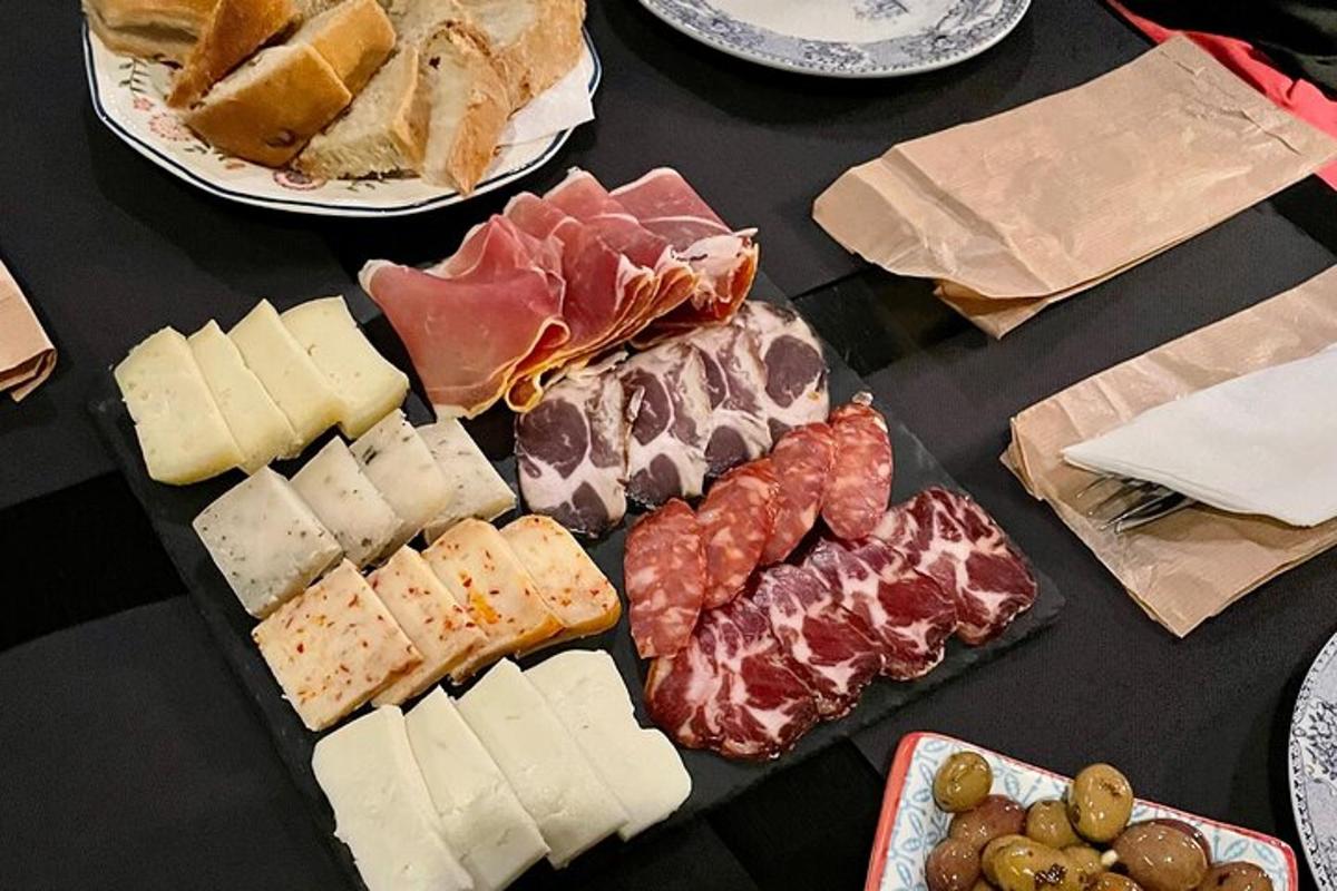 stůl prostřený různými druhy sýrů a masa