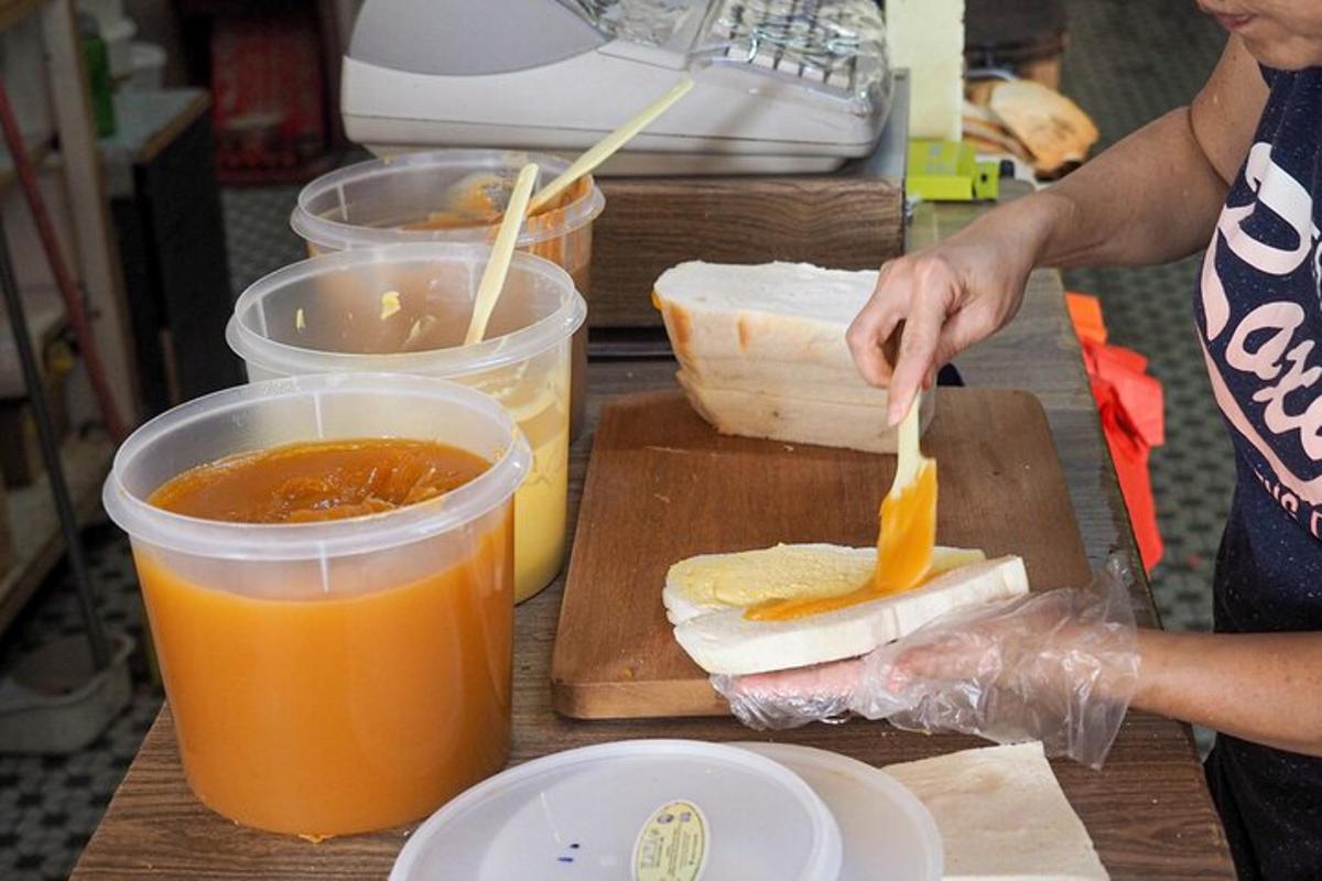 eine Frau macht ein Sandwich auf einem Schneidebrett