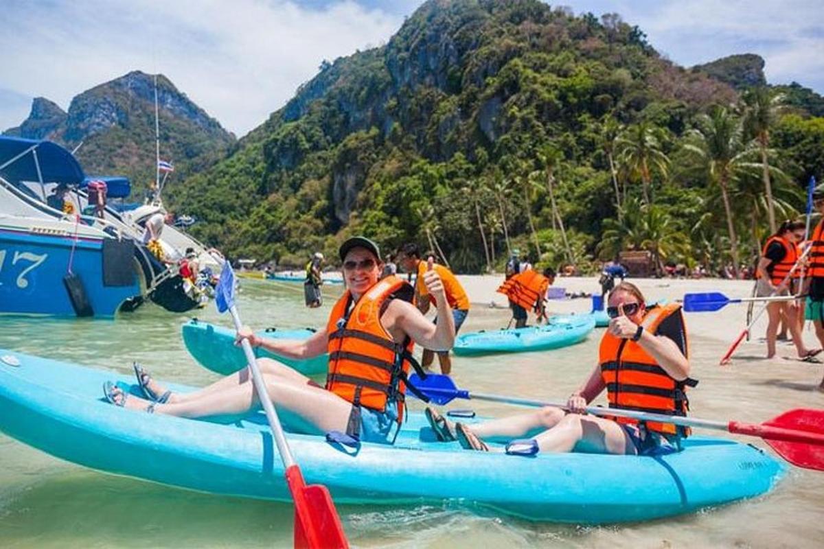 un grupo de personas en kayaks en la playa