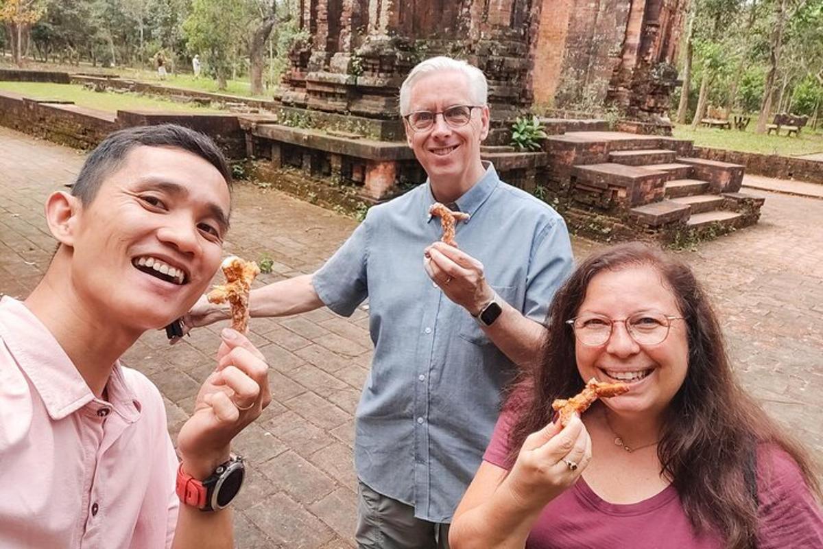 dua lelaki dan seorang wanita memegang keping piza