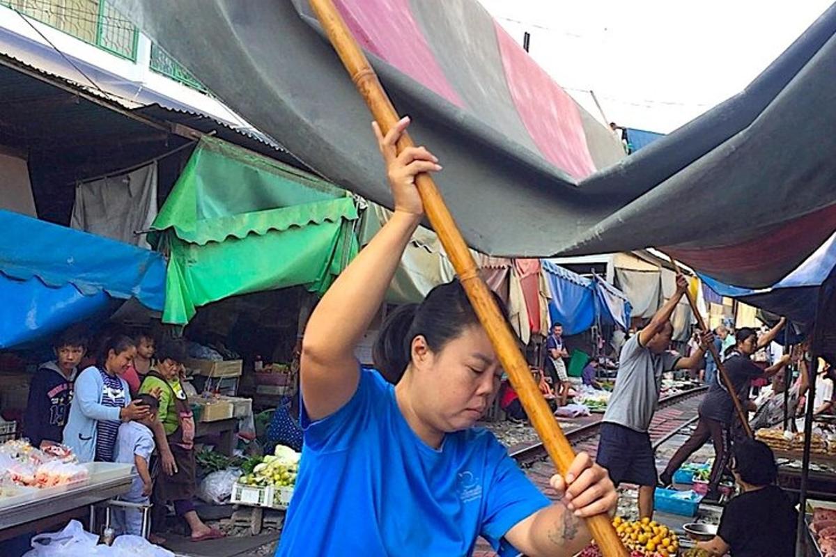 un băiat tânăr care ține o umbrelă într-o piață
