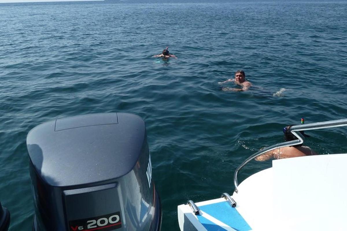 dua orang berenang di dalam air di atas bot