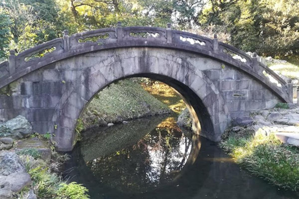 un ponte di pietra sopra un fiume in un parco