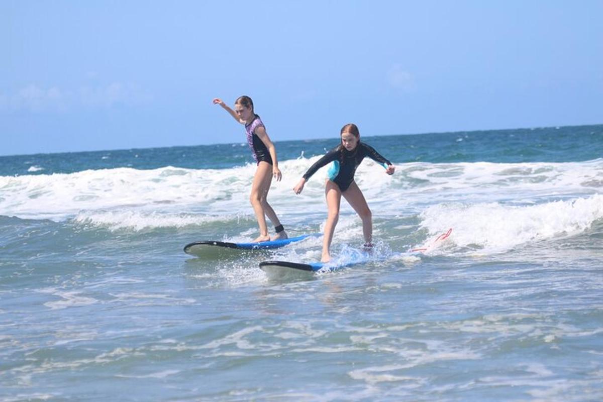 two girls are riding on surfboards in the ocean