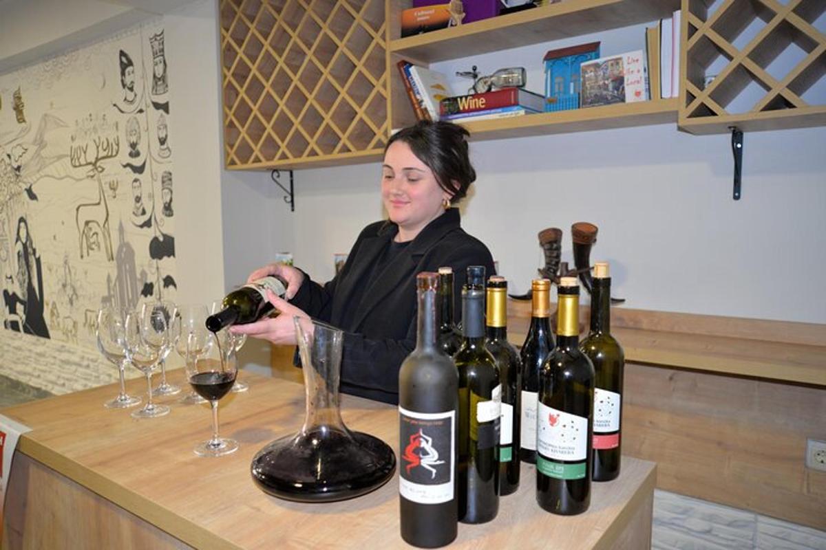 una donna che versa un bicchiere di vino in un bar