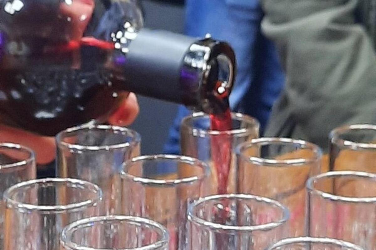 egy személy vörösbort tölt borospoharakba