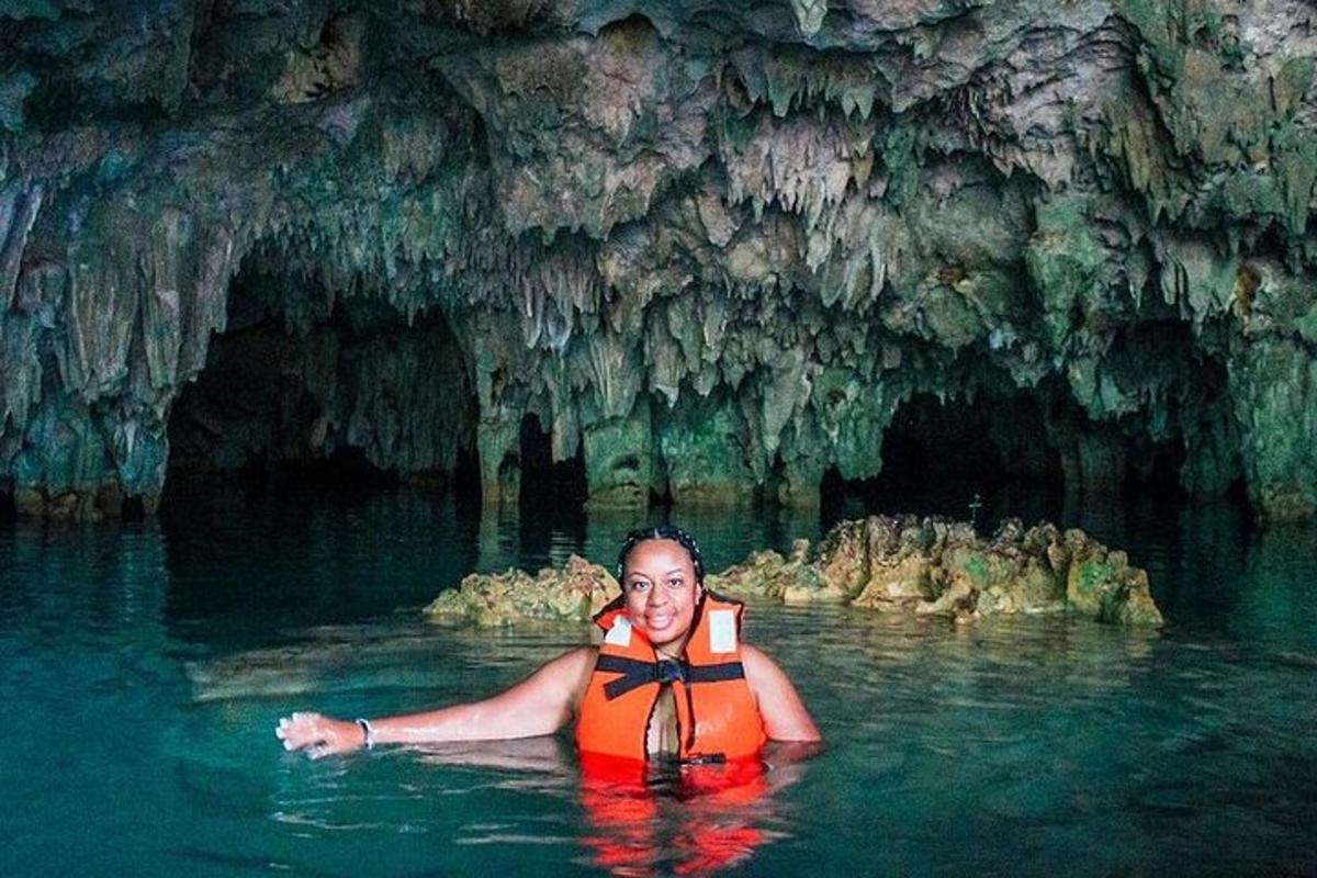 một người đàn ông dưới nước trước một hang động