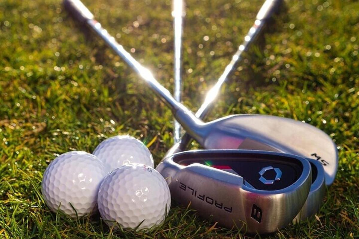 Skupina golfových holí a golfových míčků na trávě