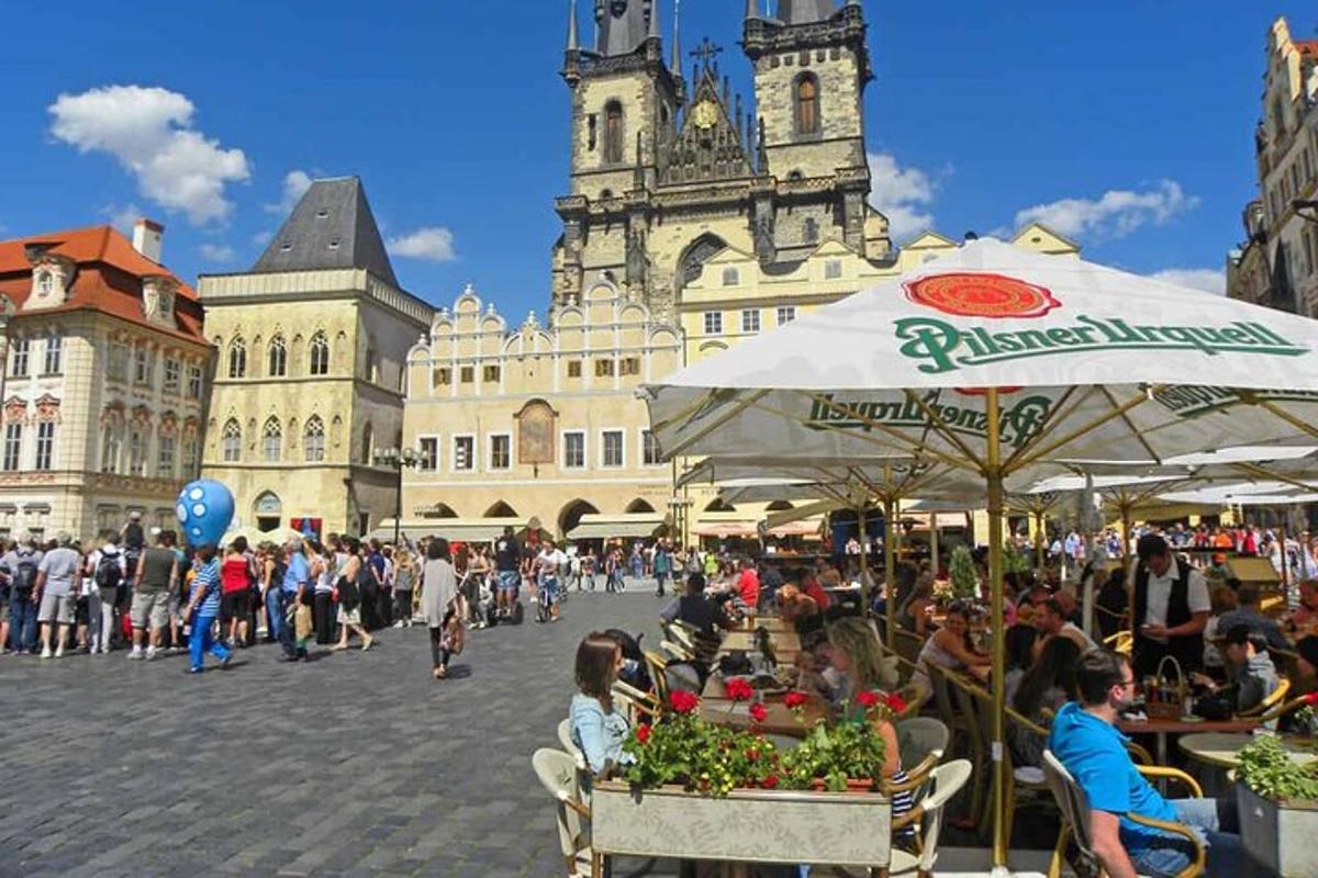 grupp inimesi, kes istuvad hoone ees laudade taga