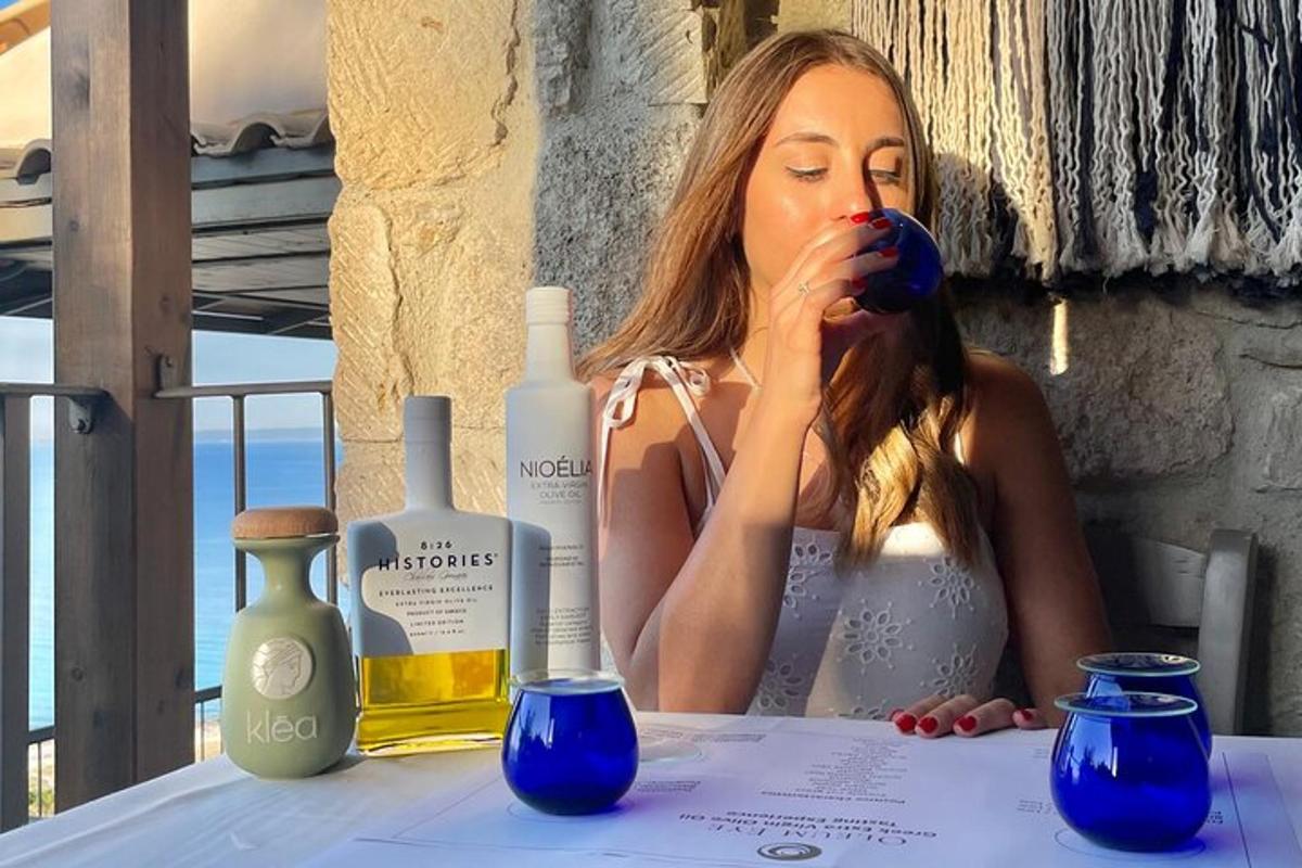 a woman sitting at a table with a bottle of wine