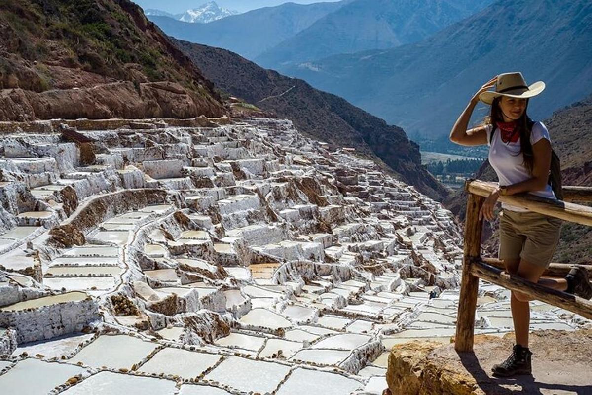 a woman is sitting on a ledge on a mountain