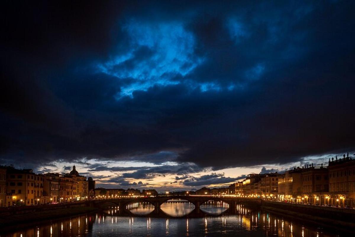 Una vista de un río por la noche con un puente.
