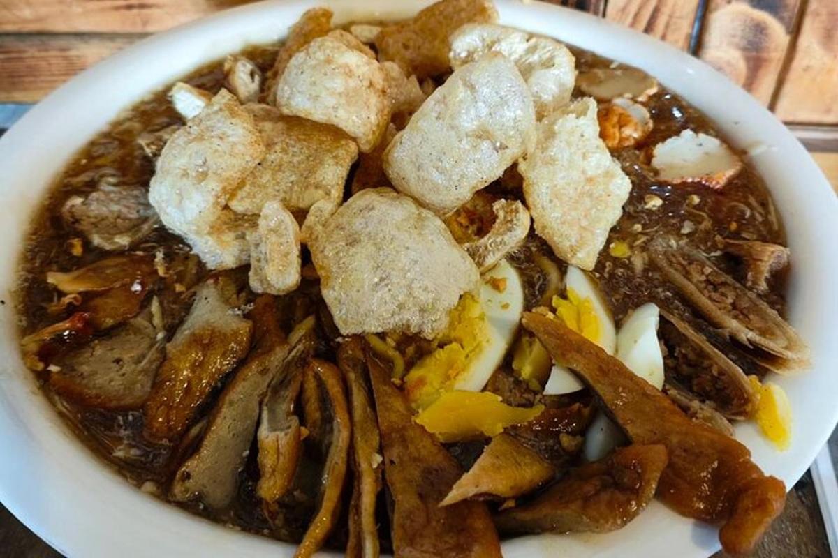a bowl of food with meat and vegetables on a table