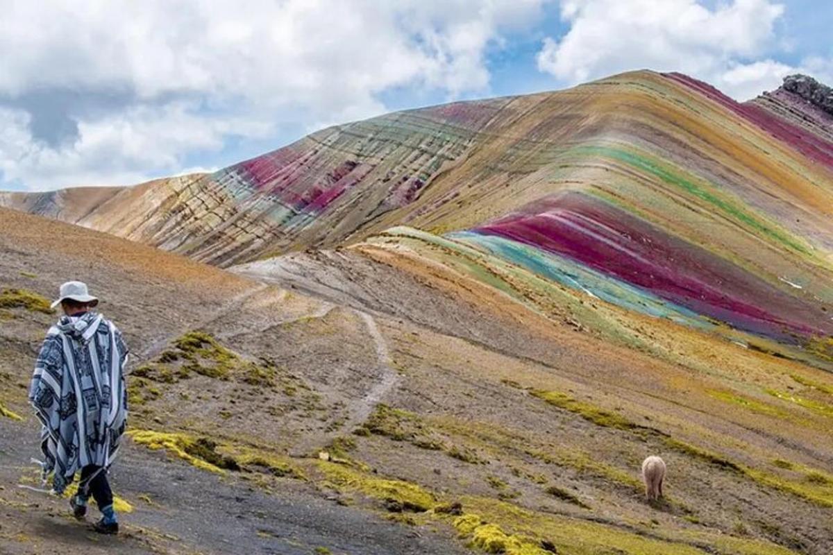 eine Person, die vor einem Regenbogenhügel geht
