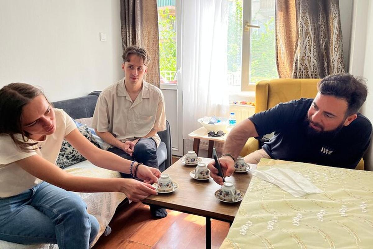 un grup de oameni așezați în jurul unei mese jucându-se cu cești de ceai