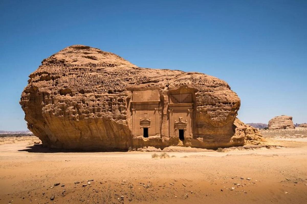 a large rock in the middle of the desert