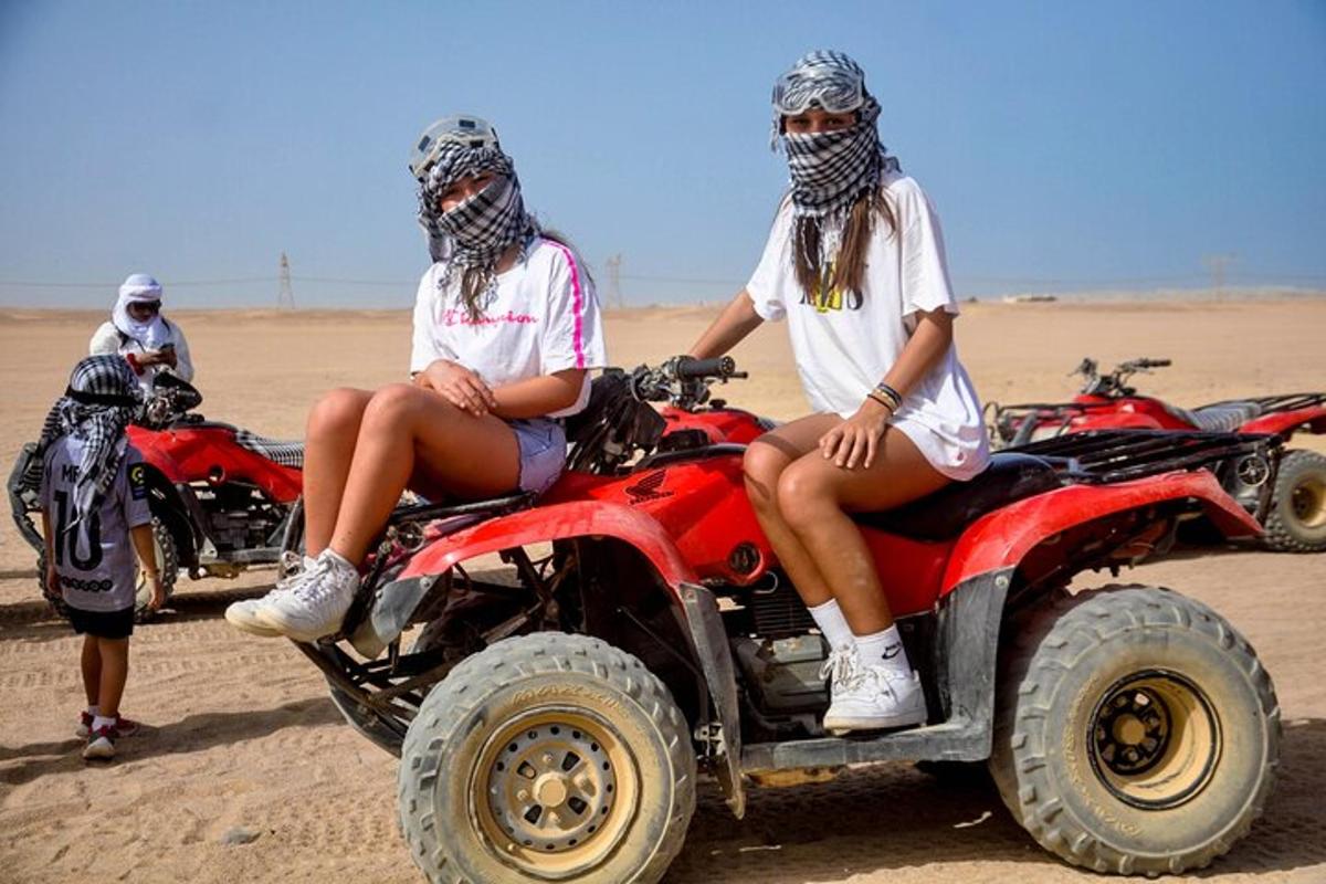 două femei stând pe ATV-uri în deșert