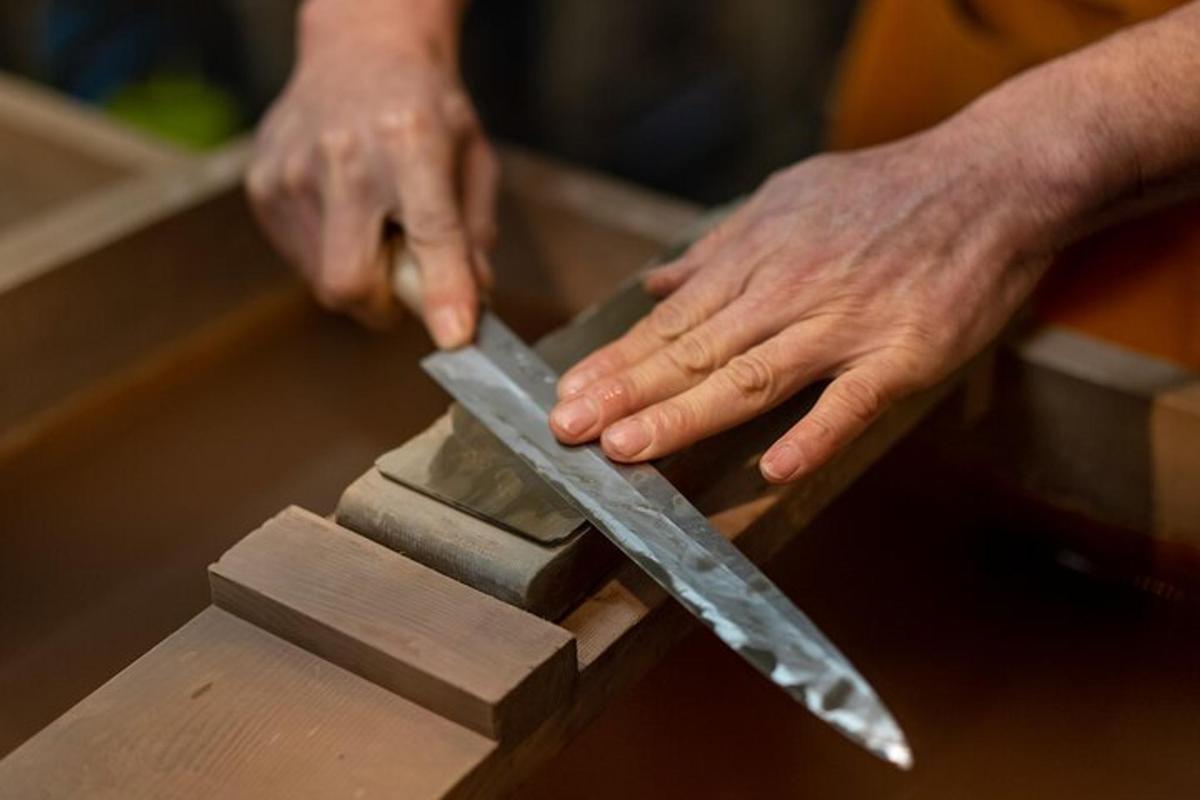 en person som holder en stor kniv på et trestykke