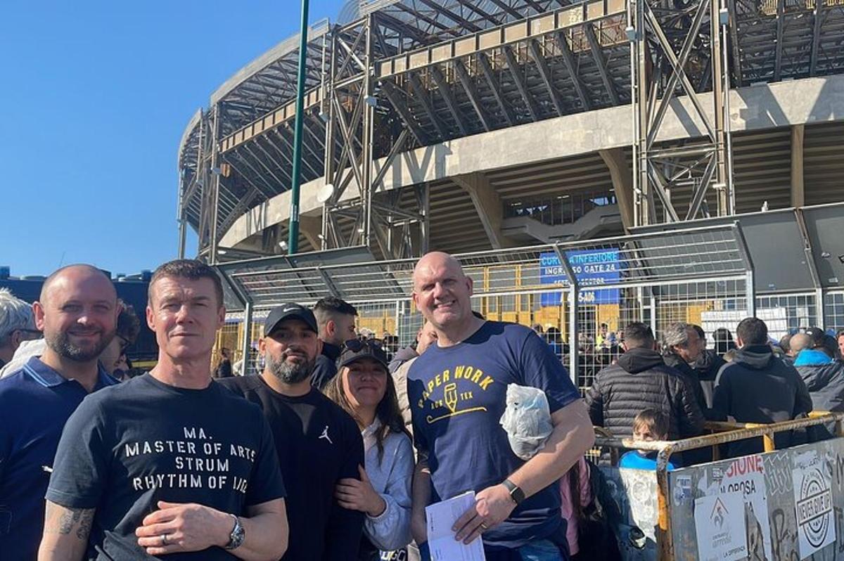 skupina lidí stojících před stadionem