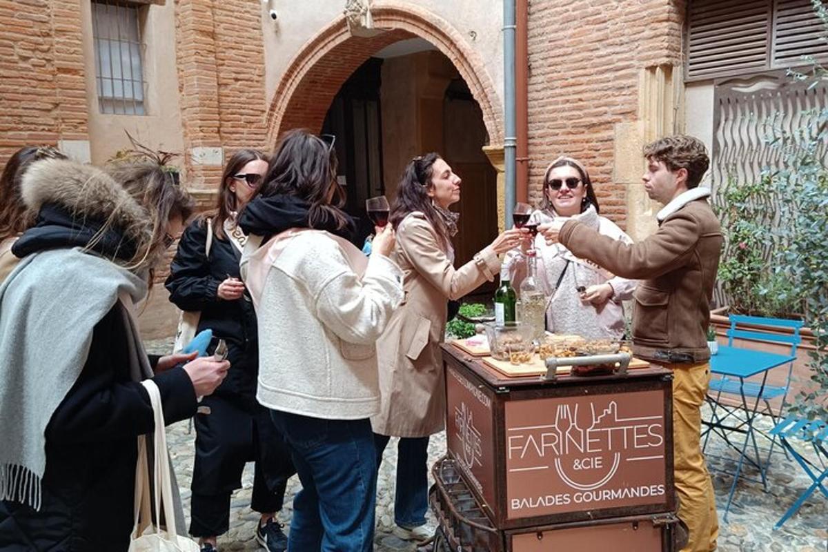 un gruppo di persone in piedi attorno a un tavolo con bicchieri di vino