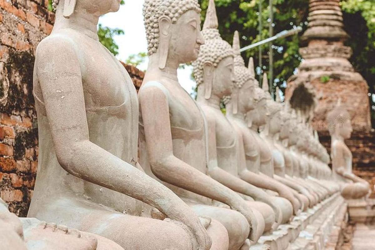 una fila di statue bianche sedute accanto a un edificio
