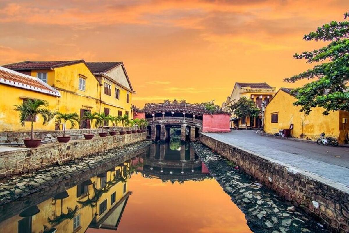 Un canal en una ciudad con edificios y una puesta de sol.