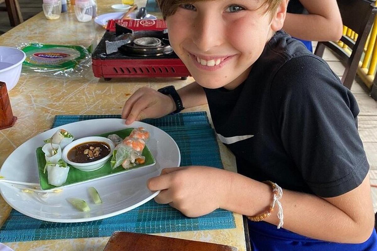 un ragazzino seduto a un tavolo con un piatto di cibo