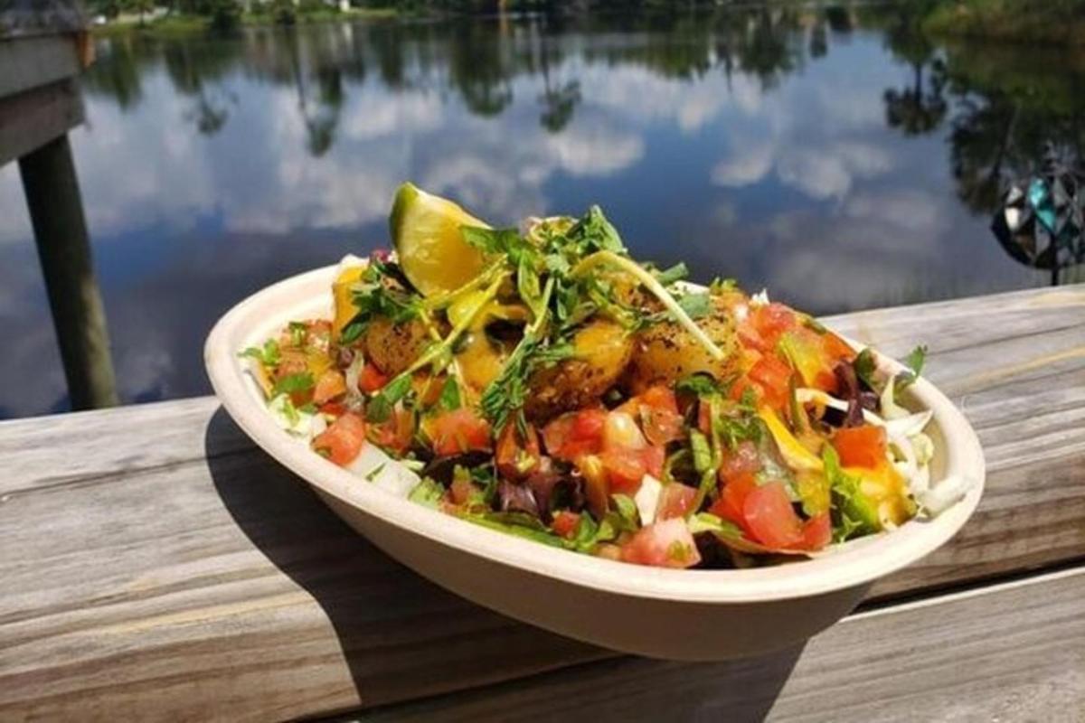 en salat i en skål på et bord nær et vandløb