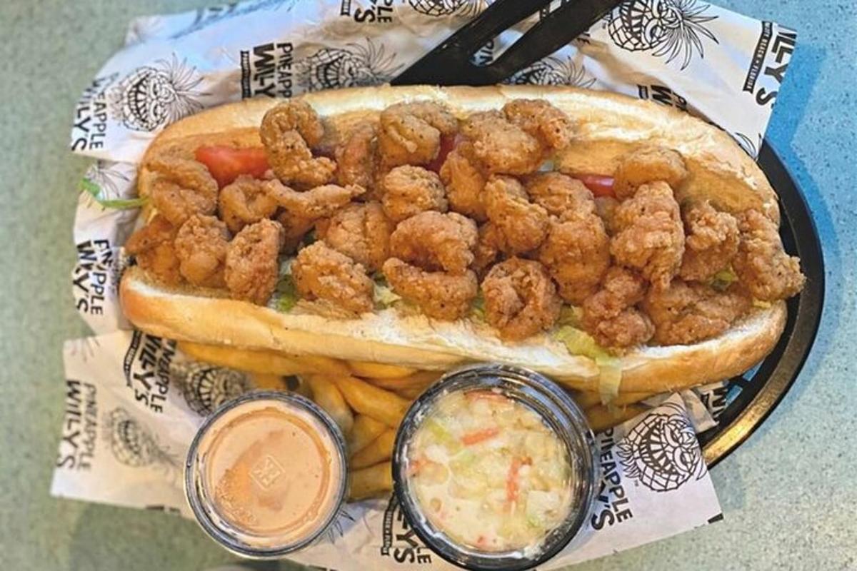 một chiếc bánh sandwich với tôm trên bánh mì kèm khoai tây chiên và nước chấm