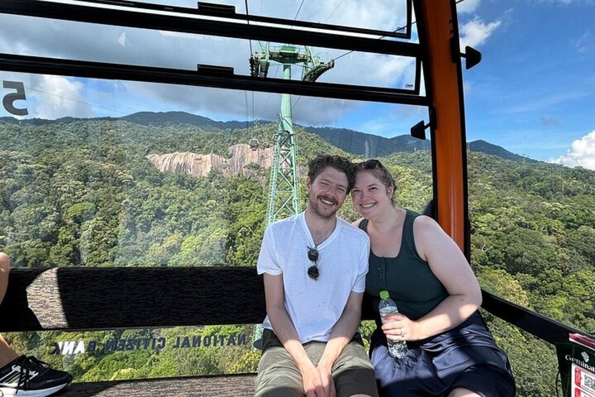 Un hombre y una mujer sentados en una góndola en las montañas azules
