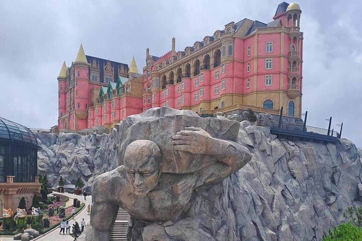 Una estatua frente a un castillo con un edificio.