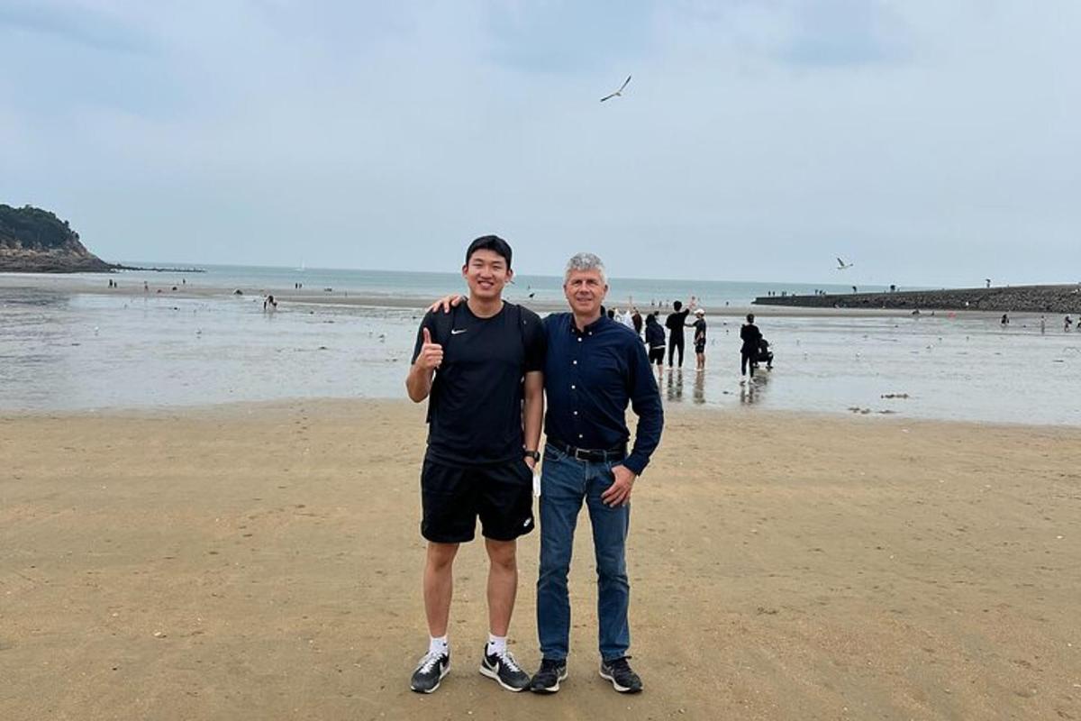 zwei Männer posieren für ein Foto am Strand
